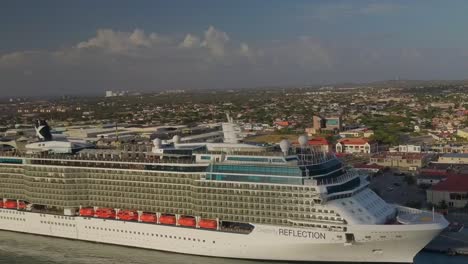 Vista-Aérea-De-La-Moto-De-Agua-Navegando-Junto-Al-Gran-Crucero-En-El-Muelle-E-Inclinando-La-Cámara-Hacia-Los-Cielos