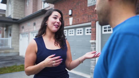 Enthusiastic-real-estate-agent-talking-to-a-client-outside-of-a-home