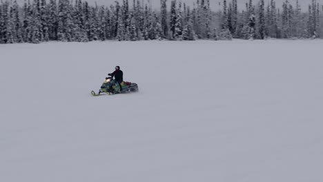Snowmobile-rider-travels-to-group-of-people-waiting-for-him,-Anchorage-4k