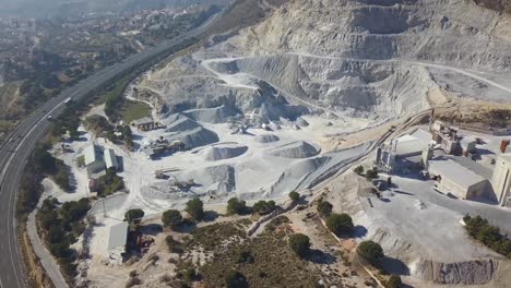Aerial-revealing-view-of-a-big-quarry-in-a-mountain
