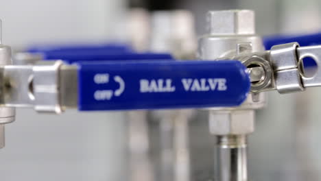 Tracking-shot-of-blue-valves-inside-a-science-lab