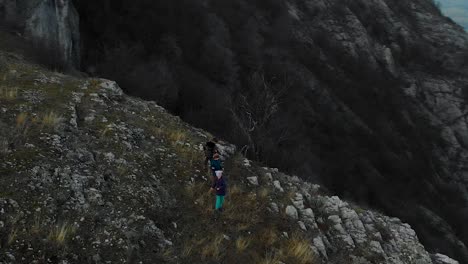 Children-play-on-edge-of-cliff---aerial-panning-shot