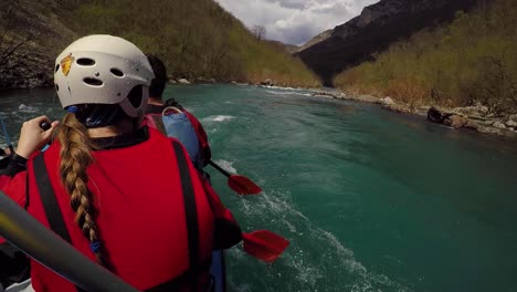 Rafting-on-river,-women-with-helmet-in-front---paddler-point-of-view