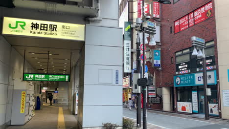 Una-Panorámica-De-La-Calle-Frente-A-La-Puerta-Sur-De-La-Estación-Kanda-Con-Tiendas.