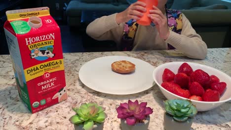 Boy-wearing-backpack-drinking-a-glass-of-Horizon-Organic-Milk-with-his-breakfast-before-heading-to-school