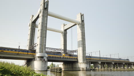 An-express-trains-runs-over-a-large-bridge-in-Gouda,-the-Netherlands