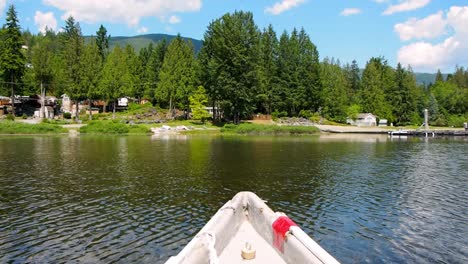 tip-of-canoe-in-lake-with-shore
