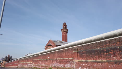 Inclinación-Revelan-La-Toma-Del-Muro-De-Seguridad-Del-Perímetro-En-La-Prisión-Hm-Manchester,-Inglaterra,-Una-Prisión-De-Alta-Seguridad-También-Conocida-Como-Vías-Extrañas-En-Un-Día-Soleado