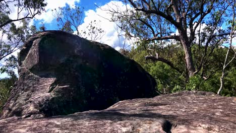 Massive-boulder-on-top-of-mountain-summit-sits-quietly-in-the-breeze