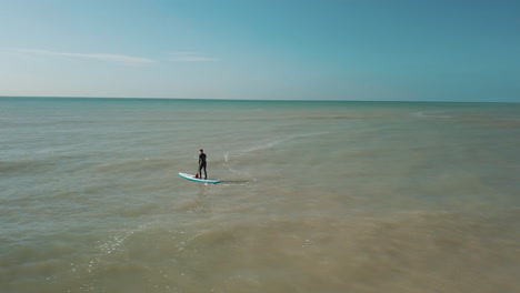Drohne-Kreist-Junger-Mann-Stand-Up-Paddle-Boarding-Im-Meer-Mit-Weißen-Klippen-Von-Dover-Im-Hintergrund