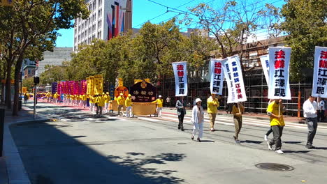 Practicantes-De-Falun-Dafa,-También-Conocido-Como-Falun-Gong,-Durante-La-Marcha-Por-Las-Calles-Del-Centro-De-San-Francisco-Protestando-Contra-La-Persecución-Religiosa-Del-Partido-Comunista-Chino-De-Jiang-Zemin