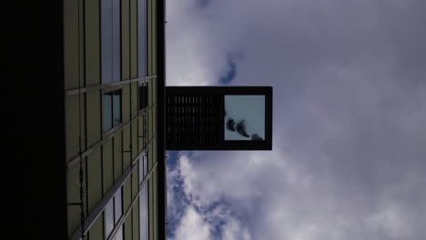 Salling-rooftop-viewpoint-on-a-glasbridge-seen-from-below-with-people-standing-on-the-glass,-during-a-summer-day-in-Aarhus,-Denmark