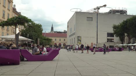 Establecimiento-De-Una-Vista-Estática-Del-Barrio-De-Los-Museos-En-Viena,-Con-Sillas-Típicas-Y-Gente-Caminando