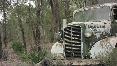 Tiro-De-Seguimiento-Hacia-Adelante-Hacia-Un-Camión-Comercial-Verde-Clásico-Abandonado-En-Bushland-Australia