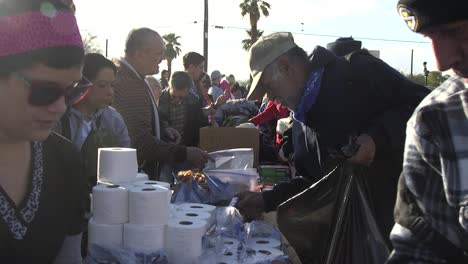 Hombre-Sin-Hogar-Obtiene-Papel-Higiénico-De-La-Bolsa-Sin-Fines-De-Lucro-A-La-Vez,-Concepto-De-Phoenix-Arizona:-Caridad,-Retribución,-Indigencia