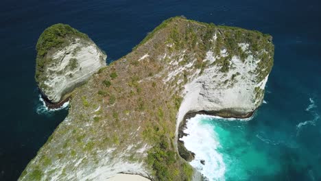 Drone-Shot-panning-down-over-the-enormous-cliffs-above-KelingKing-beach-on-the-island-of-Nusa-Penida,-Indonesia