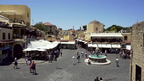 Hippocrates-Square-with-tourists-in-Rhodes-old-medieval-town,-Greece