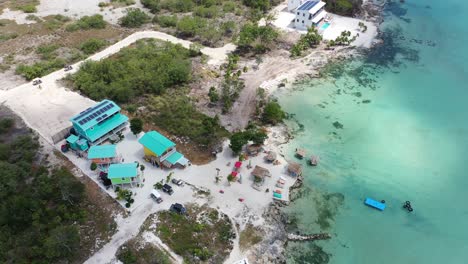 Luftaufnahme-Von-Bunten-Strandhäuschen-In-San-Pedro-Belize-Mit-Wunderschönem-Türkisfarbenem-Wasser