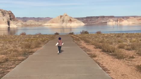 Junge-Hüpft-Glücklich-Vor-Freude-Zum-Strand-In-Lake-Powell,-Arizona