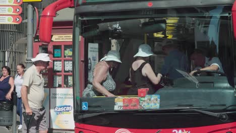 Tourists-with-sunhats-get-on-sightseeing-bus-in-Jerez,-Spain,-Slow-Motion