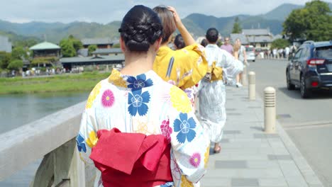 Schönes-Mädchen,-Das-Einen-Traditionellen-Kimono-Trägt,-Der-Ein-Bild-Des-Flusses-Macht,-Der-über-Die-Brige-In-Kyoto,-Japan-Geht,-Sanfte-Beleuchtung,-Zeitlupe-4k