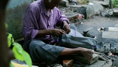 A-cobbler-repairing-slippers-of-pilgrims-by-the-roadside-in-the-morning-stock-footage-collection-6