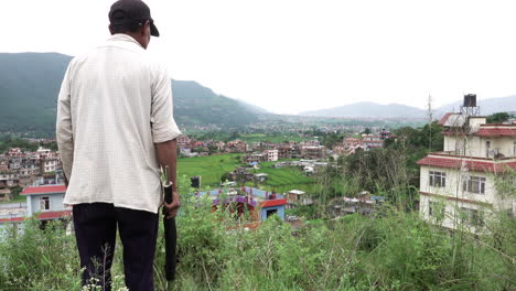 Kathmandu,-Nepal---September-29,-2019:-An-old-Nepali-man-getting-angry-with-his-grazing-sheep-down-over-a-hillside-in-Kathmandu,-Nepal-on-September-29,-2019