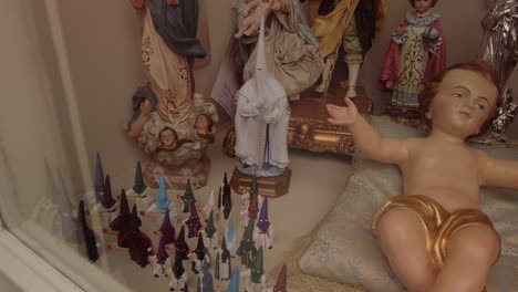 Spanish-figurines-of-penitentes-and-baby-Jesus-in-window-display,-Closeup-Detail