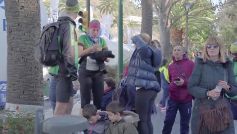 Female-participant-takes-sweatshirt-from-backpack,-Zurich-Malaga-Marathon
