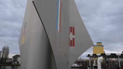 Close-up-shot,-statue-border-of-Switzerland,-France-and-Germany-in-Basel,-Ferry-boat-in-the-background