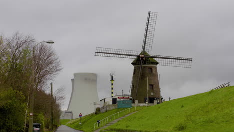 Ein-Traditionelles-Windmühlenhaus-Auf-Einem-Hügel-Bei-Einem-Kernkraftwerk-In-Belgien-An-Einem-Bewölkten-Tag---Weitschuss
