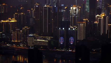 Horizonte-De-La-Ciudad-Por-La-Noche-Que-Muestra-La-Proyección-De-La-Ventana-En-Los-Edificios-Junto-Al-Río-Jialing,-Tiro-De-Establecimiento-Manual