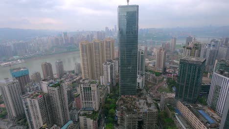 Lapso-De-Tiempo-Diurno-Del-Rascacielos-Verde-En-Construcción-Cerca-Del-Río-Yangtze-Mientras-Las-Nubes-Avanzan-Y-El-Sol-Brilla