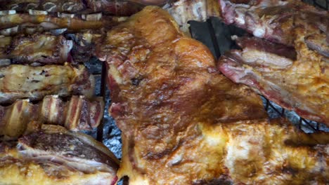 Big-cuts-of-meat-cooking-slowly-over-hot-charcoal-in-an-Argentinian-Asado