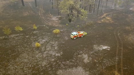 Los-Bomberos-Inspeccionan-El-Suelo-Quemado-Quemado-Cerca-Del-Camión-De-Bomberos-Del-Incendio-Forestal-De-Eucalipto,-El-Sobrevuelo-De-Drones-Aéreos-Revela-El-Disparo