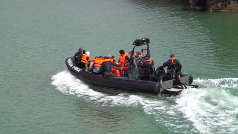 Border-force-officer-bring-migrant-into-Dover-port,-Kent,-UK