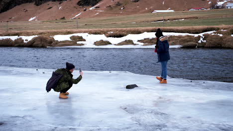 Dolly-shot-showing-male-person-taking-a-picture-of-posing-girl-in-iceland-with-smartphone,Europe