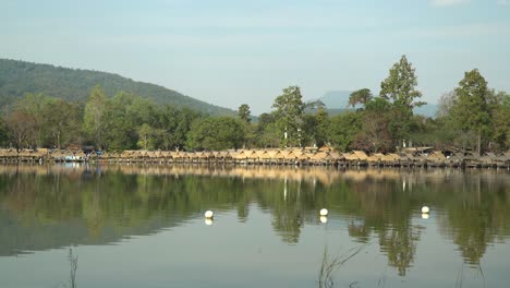 Schöner-Huay-Tung-Tao-See-In-Chiang-Mai-Mit-Einer-üppigen-Bergkulisse,-Die-Die-Strohhütten-Am-Seeufer-Zeigt