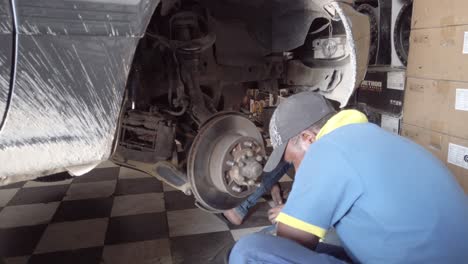 Mechanics-working-on-a-car's-axle-trying-to-fix-it