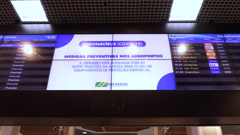 Tablero-De-Información-En-El-Aeropuerto-De-La-Ciudad-De-Santos-Dumont-De-Vuelos-Nacionales-Con-Horario-De-Salida-E-Instrucciones-Sobre-Medidas-Preventivas-Relacionadas-Con-El-Brote-Del-Virus-Covid-19,-Como-El-Uso-De-Una-Máscara-Facial