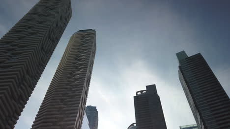 Slow-moving-shot-of-tall-waterfront-buildings-towering-in-the-sky