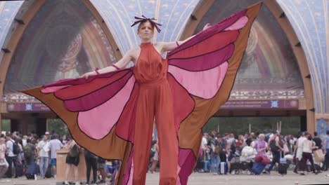 Elegante-Stelzenläuferin-Unterhält-Festivalbesucher-Am-Eingang-Des-Campingplatzes-Dreamville,-Tomorrowland,-Belgien