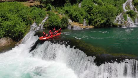 Los-Equipos-De-Rafting-En-El-Río-Bajan-Un-Salto-En-La-Cascada-Strbacki-Buk-En-El-Río-Una-En-La-Frontera-Con-Bosnia---Herzegovina,-Plano-Aéreo-Izquierdo