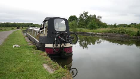 Barco-Angosto-Del-Canal-Británico-Amarrado-A-Lo-Largo-De-La-Pintoresca-Campiña-Inglesa-Vía-Fluvial