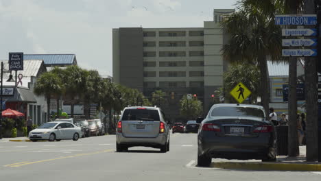 Cars-Pass-By-on-Folly-Beach-Strip-on-Sunny-Day,-Static