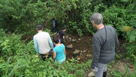 Group-of-hikers-tourists-is-climbing-a-steep-trail-down-a-mountain-in-jungle-of-Ecuador