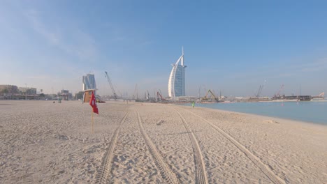 Dubai-sand-beach-and-Burj-Al-Arab-Hotel,-United-Arab-Emirates