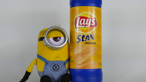 Minion-Zeichentrickfigur-Mit-Lay-Chips,-Minions,-Gelb,-Kommerzielle-Illustration,-Süß,-Lustig,-Auge,-Blick,-Brille,-Emoji,-Glücklicher-Kopf,-Animation,-Film,-Berühmtes-Spielzeug,-Gesichtsbehandlung,-Nahaufnahmegesicht,-Comic-Puppe