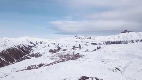 Flight-over-high-Alborz-mountain-village-in-winter-snow-beautiful-white-landscape