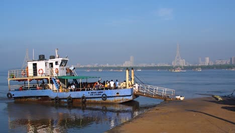 Eine-Kleine-Fähre-Oder-Ro-Ro-Fähre-Mit-Passagieren-Und-Besatzung,-Die-Auf-Mehr-Menschen-Und-Passagiere-In-Der-Nähe-Eines-Hafen--Oder-Hafenvideohintergrunds-Warten